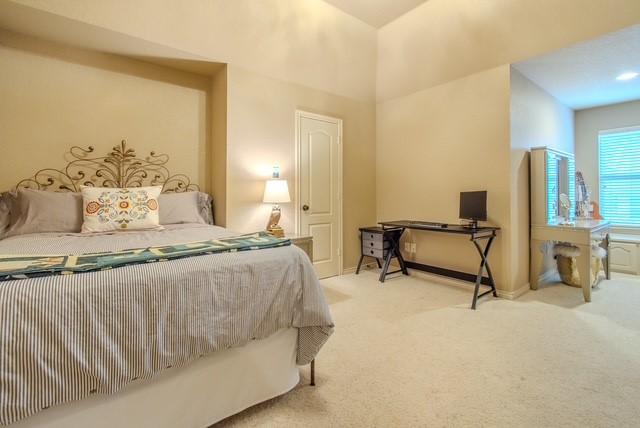 bedroom with baseboards and light colored carpet