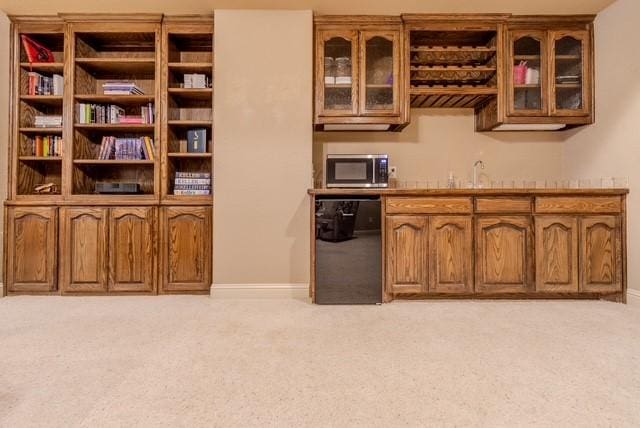 bar featuring wet bar, black dishwasher, stainless steel microwave, and light carpet