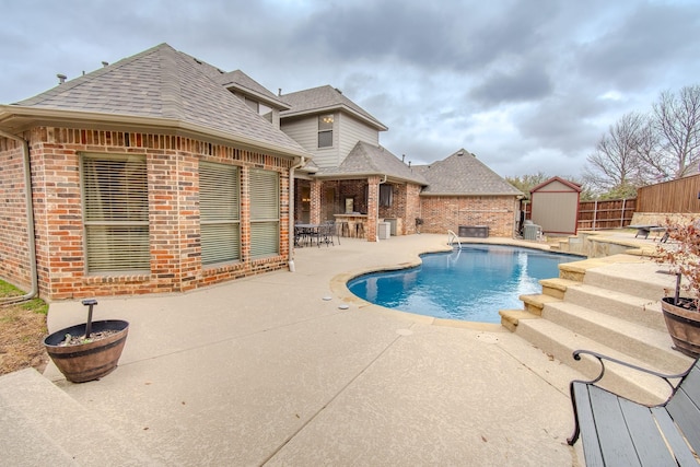 view of pool with a fenced in pool, an outbuilding, a patio, a storage unit, and fence