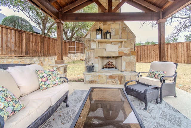 view of patio / terrace with a gazebo, an outdoor living space with a fireplace, and a fenced backyard