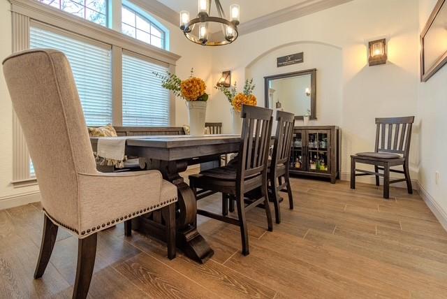 dining space featuring a chandelier, ornamental molding, wood finished floors, and baseboards