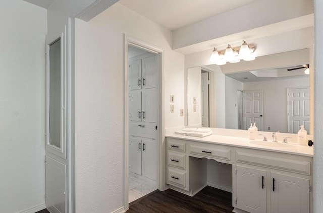 bathroom featuring baseboards, wood finished floors, vanity, and a ceiling fan