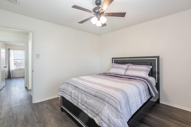 bedroom with ceiling fan, visible vents, baseboards, and wood finished floors