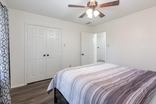 bedroom featuring ceiling fan, a closet, visible vents, and dark wood-style flooring