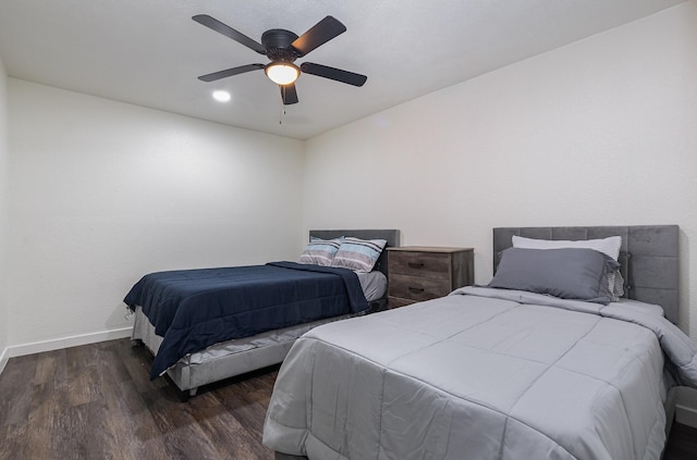 bedroom featuring baseboards, dark wood finished floors, and a ceiling fan