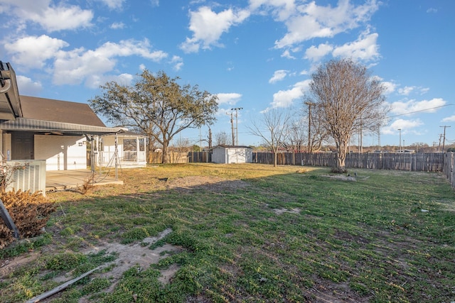 view of yard with an outbuilding, a patio, a storage shed, and a fenced backyard