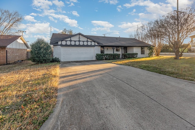 view of front of house featuring a garage, driveway, a front lawn, and brick siding