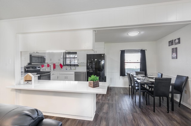 kitchen featuring white cabinets, dark wood-style floors, appliances with stainless steel finishes, light countertops, and a sink