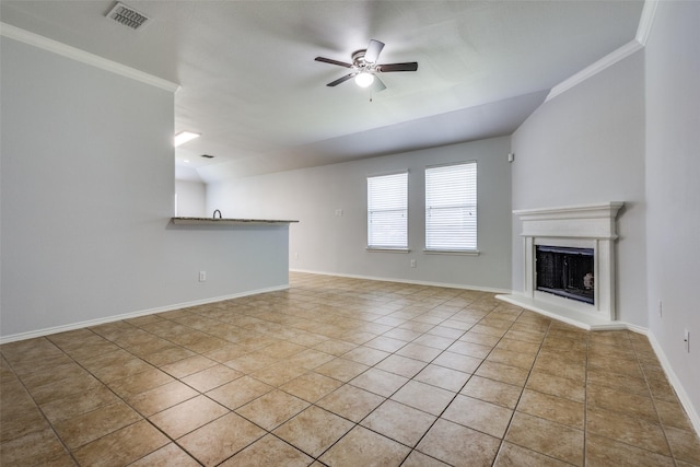 unfurnished living room featuring visible vents, a fireplace with raised hearth, a ceiling fan, ornamental molding, and baseboards