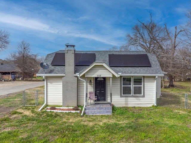 view of front of property with a shingled roof, a gate, fence, and a front lawn