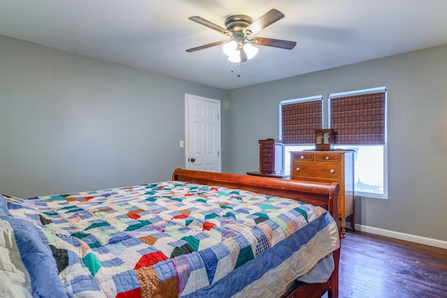 bedroom with ceiling fan, wood finished floors, and baseboards