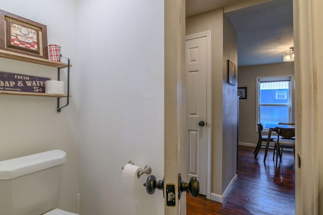 bathroom with baseboards, toilet, and wood finished floors