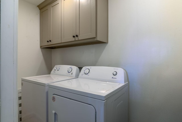 clothes washing area with cabinet space and independent washer and dryer