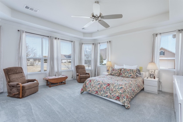 carpeted bedroom featuring a raised ceiling, visible vents, and baseboards