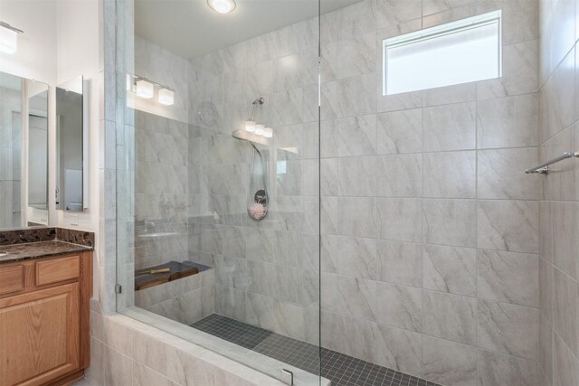 bathroom featuring walk in shower and vanity