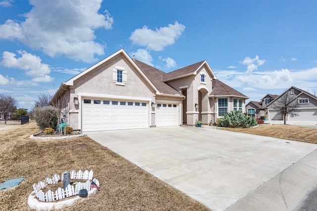 traditional-style home with a garage, concrete driveway, and stucco siding