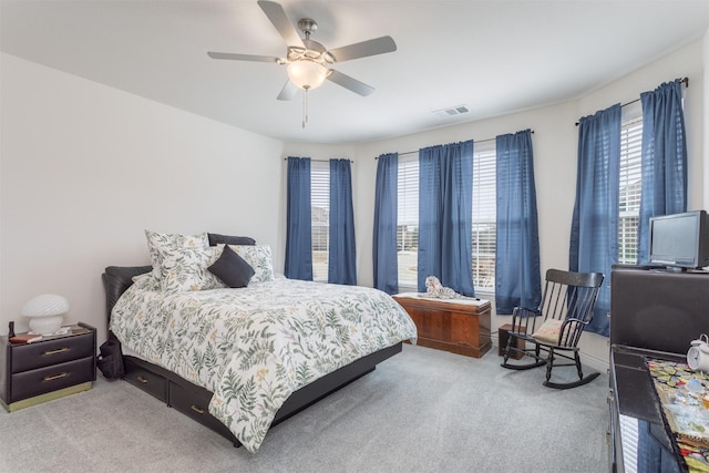 carpeted bedroom featuring ceiling fan, multiple windows, and visible vents