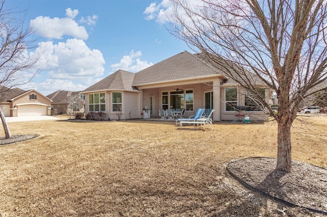 back of house with a shingled roof, a lawn, a patio area, and stucco siding