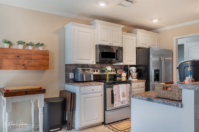 kitchen featuring stainless steel appliances, tasteful backsplash, visible vents, ornamental molding, and white cabinets