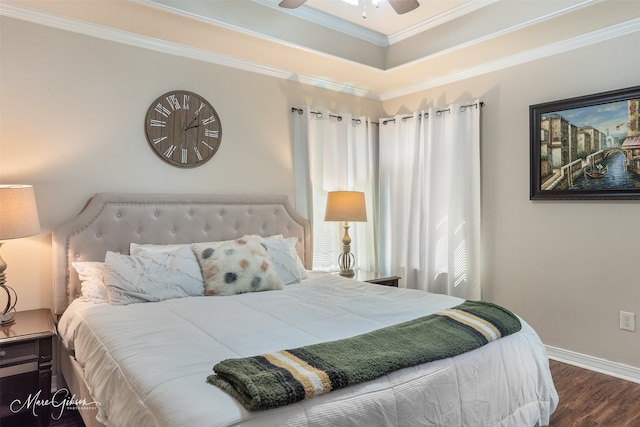 bedroom featuring ornamental molding, a raised ceiling, baseboards, and wood finished floors