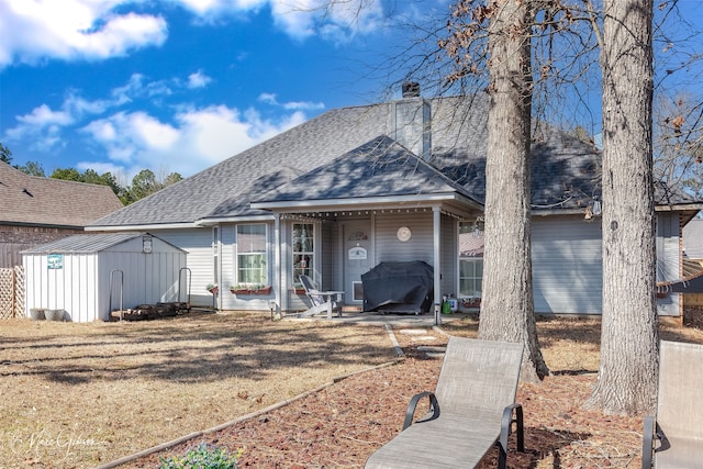 view of front of house featuring a storage shed, roof with shingles, an outdoor structure, and a chimney