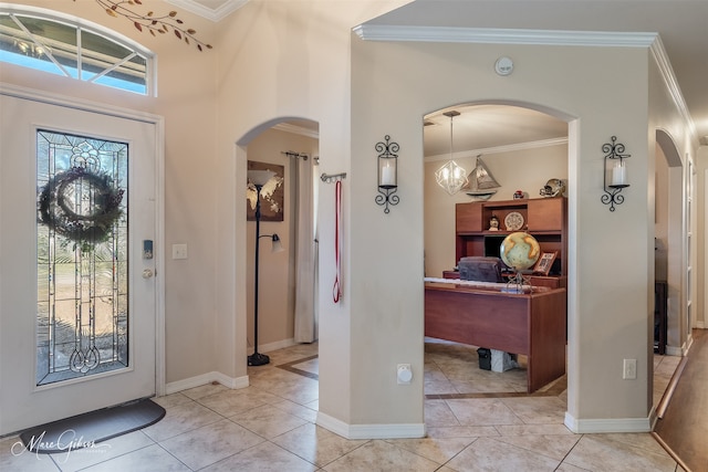 entryway featuring arched walkways, ornamental molding, and light tile patterned floors