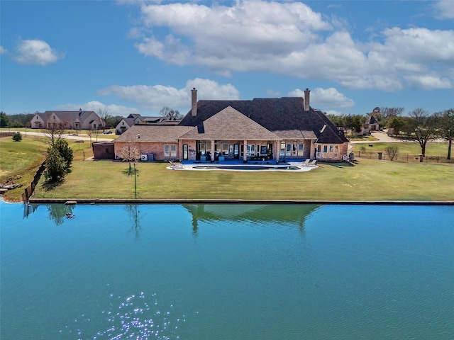 exterior space featuring a water view, a swimming pool, a lawn, and a patio