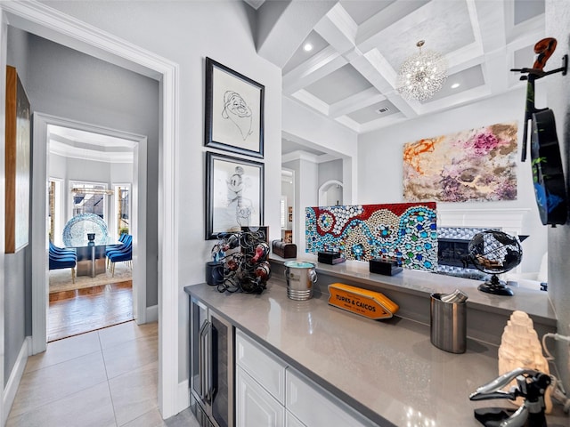 kitchen featuring a notable chandelier, light tile patterned floors, white cabinetry, coffered ceiling, and beamed ceiling