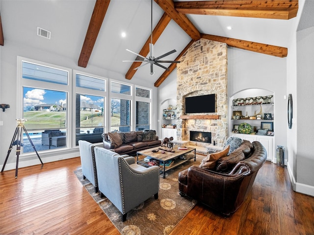 living area featuring high vaulted ceiling, hardwood / wood-style flooring, a fireplace, and visible vents