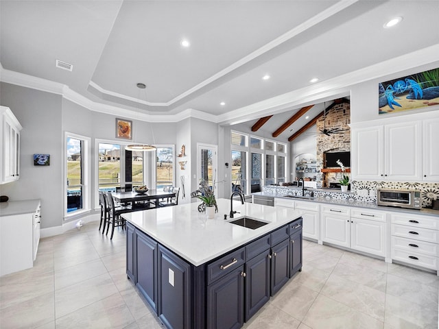 kitchen featuring light countertops, visible vents, a sink, and white cabinetry