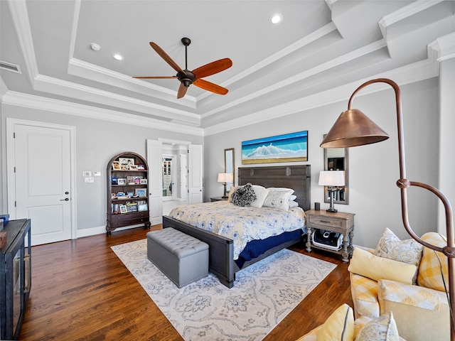 bedroom featuring recessed lighting, dark wood-style flooring, visible vents, ornamental molding, and a tray ceiling