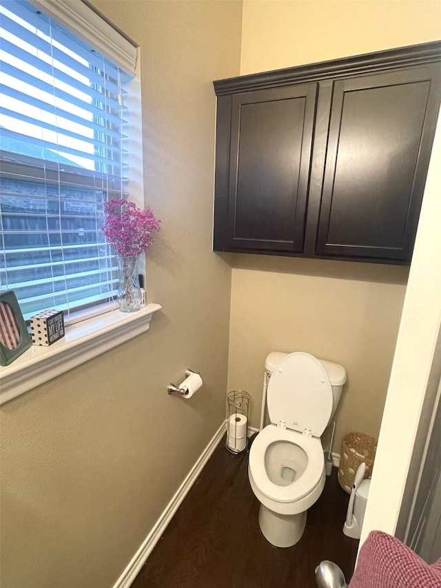 bathroom featuring toilet, baseboards, and wood finished floors