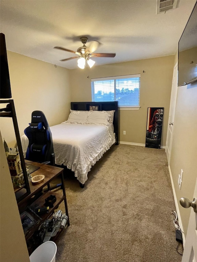 carpeted bedroom with baseboards, visible vents, and a ceiling fan