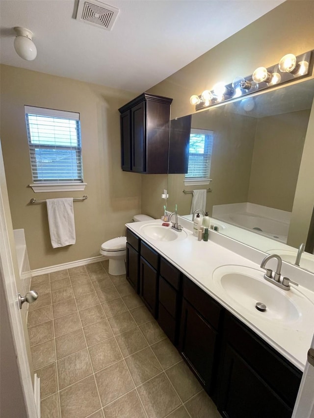 full bath featuring a garden tub, visible vents, a sink, and toilet