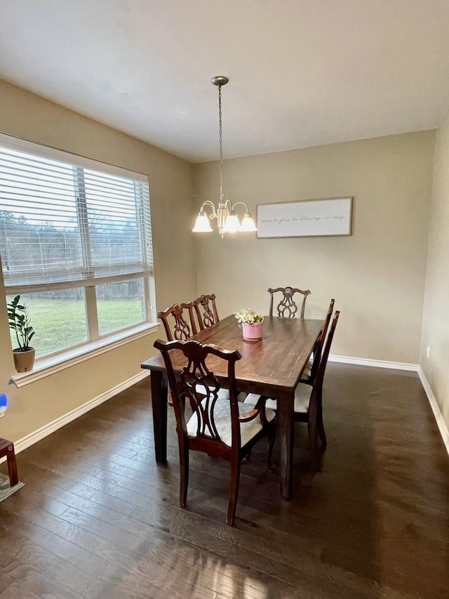 dining space featuring baseboards, dark wood-style floors, and a notable chandelier