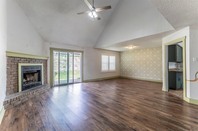 unfurnished living room with a fireplace, a textured ceiling, and wallpapered walls