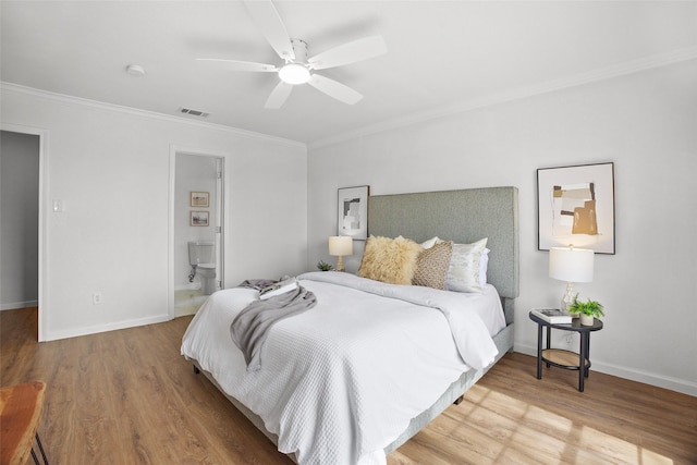 bedroom with visible vents, crown molding, baseboards, and wood finished floors