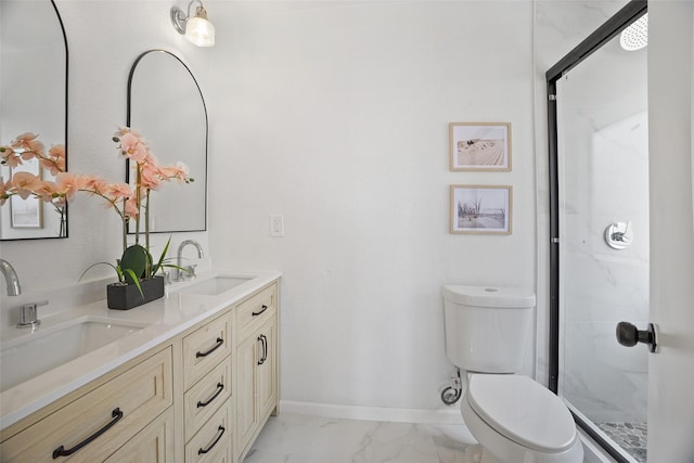 bathroom featuring toilet, marble finish floor, baseboards, and a sink