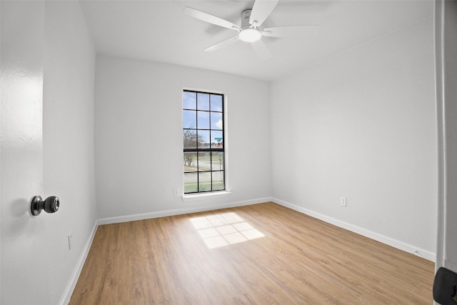 empty room featuring a ceiling fan, baseboards, and wood finished floors