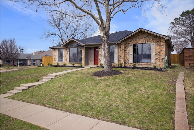 view of front of home featuring brick siding, an outdoor structure, a front lawn, and roof with shingles