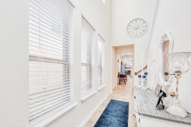 hallway featuring light tile patterned floors and baseboards