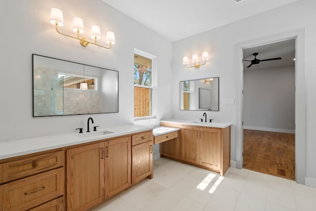 full bath with two vanities, a sink, baseboards, and ceiling fan