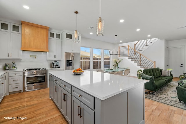 kitchen with appliances with stainless steel finishes, gray cabinets, visible vents, and light wood-style flooring