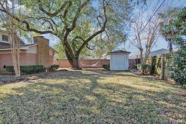 view of yard featuring an outbuilding, a shed, and a fenced backyard