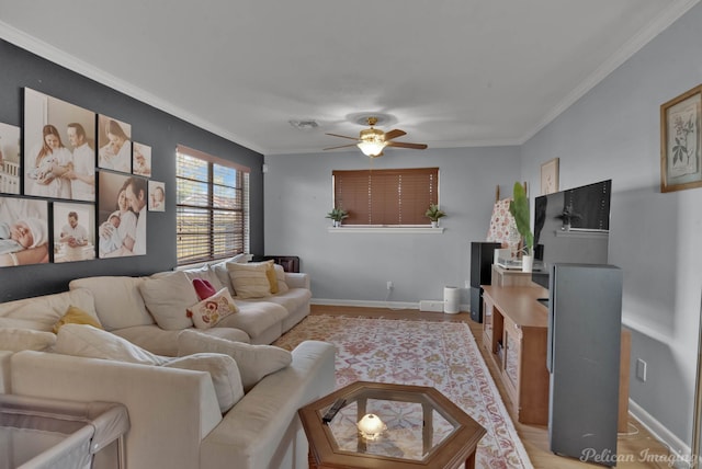 living room featuring light wood-style floors, ceiling fan, ornamental molding, and baseboards