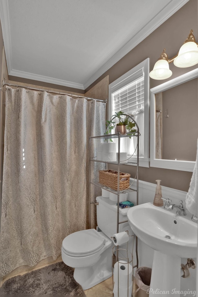 full bathroom featuring a shower with shower curtain, a sink, toilet, and crown molding