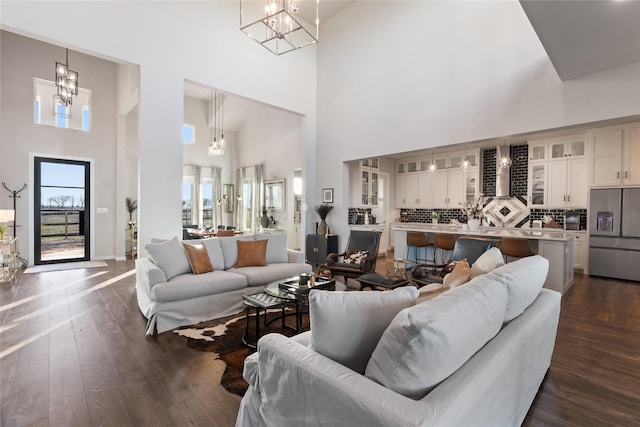 14402 Stice Rd, Krum, TX 76249 - living area featuring a chandelier, a high ceiling, dark wood-style floors, and baseboards