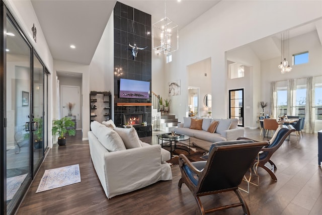 14402 Stice Rd, Krum, TX 76249 - living room featuring a high ceiling, a chandelier, a tiled fireplace, and dark wood-style flooring