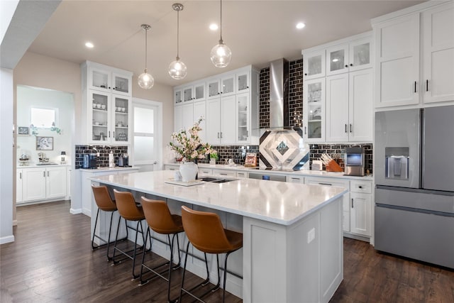 14402 Stice Rd, Krum, TX 76249 - kitchen with stainless steel fridge with ice dispenser, wall chimney exhaust hood, a kitchen island with sink, backsplash, and white cabinetry