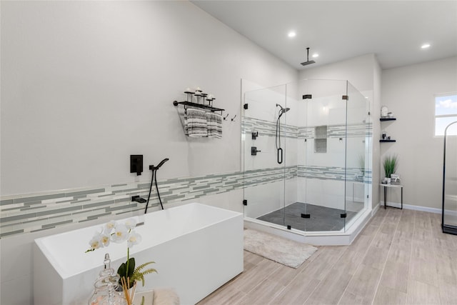 14402 Stice Rd, Krum, TX 76249 - bathroom featuring a stall shower, recessed lighting, a soaking tub, wood finished floors, and tile walls